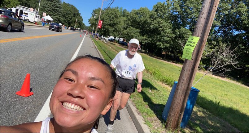 Larry Kessler trails his daughter Alana, who had already finished the Arnold Mills 4-Miler in 34:17 on the Fourth of July, as he heads to the finish line. He did the race in 58:41. Alana went back on the course to encourage her very slow father to finish the race.